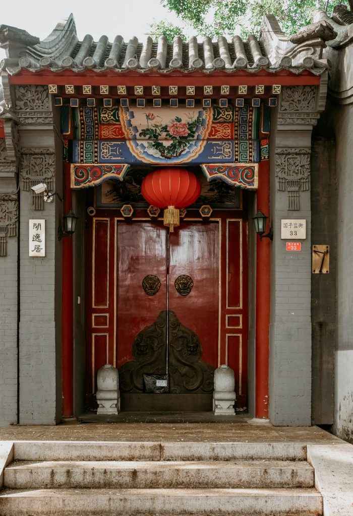 Historische rote Tür mit Lampion in einem Hutong in Peking. 