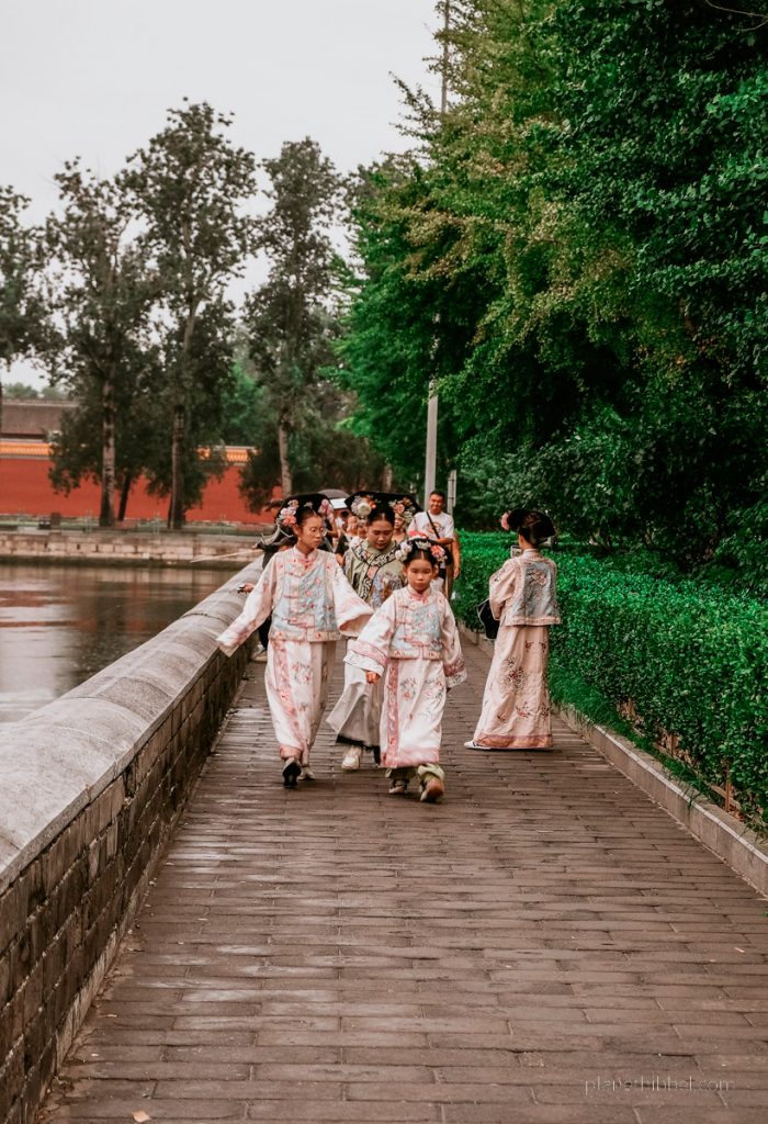 Traditionell gekleidete chinesische Kinder einen Weg entlang laufen. 