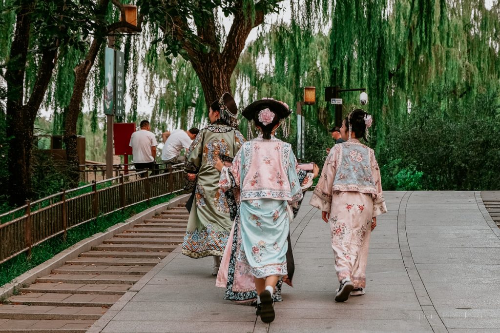 Chinesische Frauen in traditionellen Gewändern in einem Park in Peking. 
