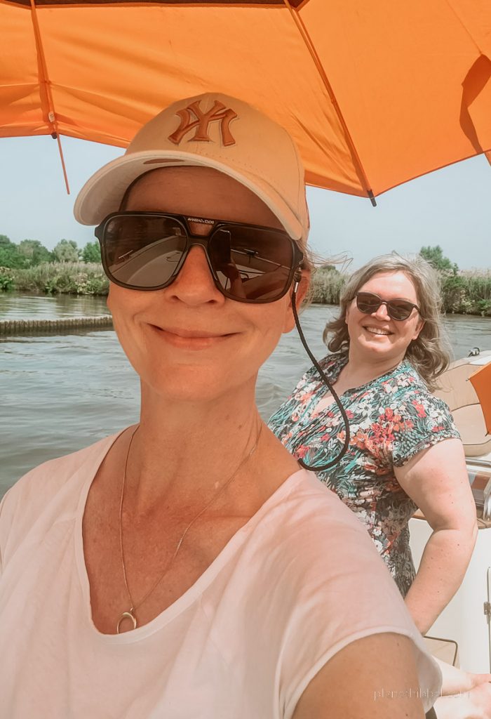 Zwei Frauen mit Schirm auf einem Touristenboot in Gent. 