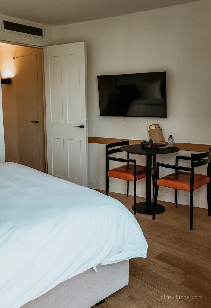 Zimmeransicht mit Bett, Tisch und Stühlen im Hotel Nenuphar an der Leihe.