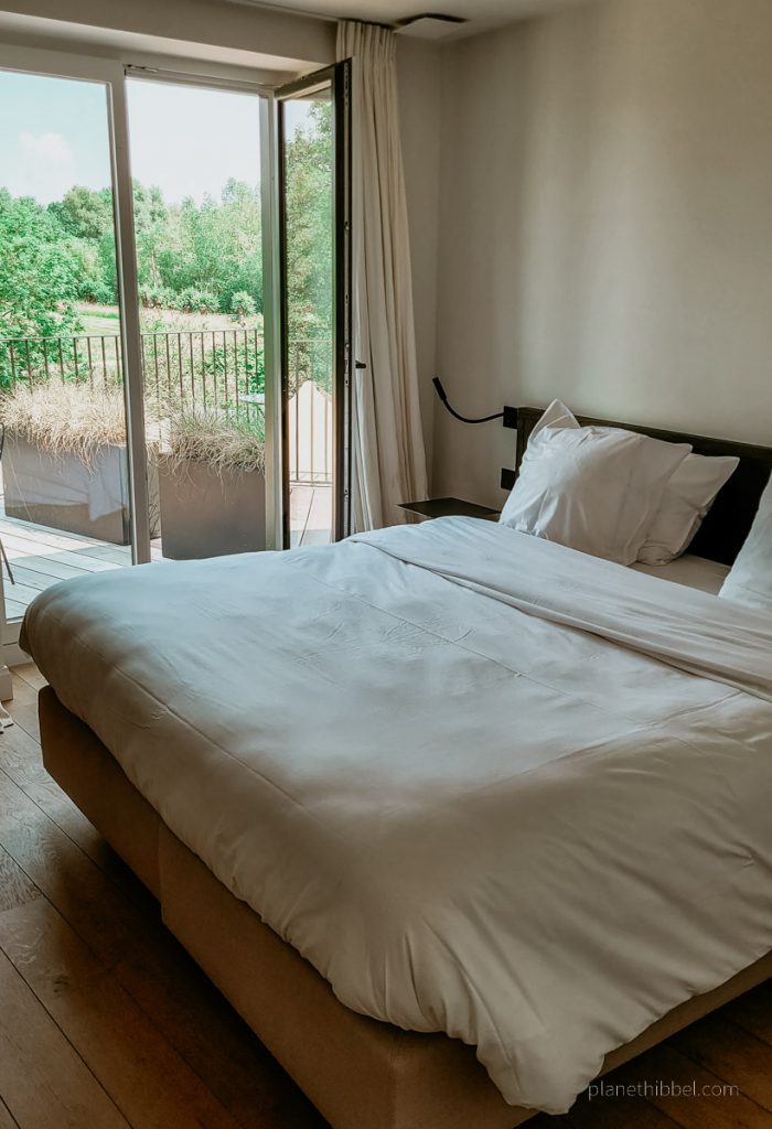 Zimmeransicht mit Bett und Balkontür im Hotel Nenuphar.
